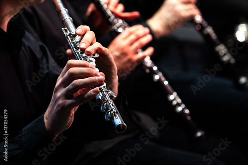 Hands of a musician playing the flute in an orchestra 