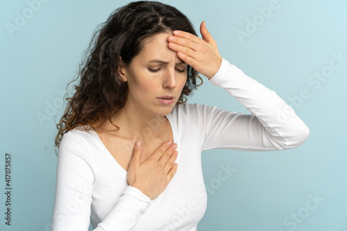 Breathing, respiratory problem, asthma attack, pressure, chest pain, sun stroke, dyspnea concept. Studio portrait of woman received heatstroke in hot summer weather, touching her forehead, isolated