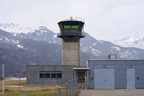 Flight control tower of military airbase with snow mountain panorama in the background. Photo taken February 26th, 2021, Meiringen, Switzerland.