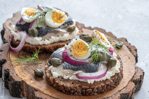 Danish open sandwich smorrebrod with herring, onion and eggs