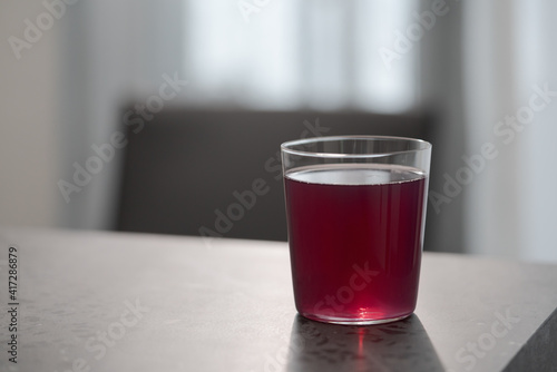 purple drink in tumbler glass on concrete countertop with copy space