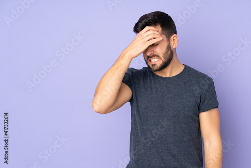 Caucasian handsome man with headache over isolated purple background