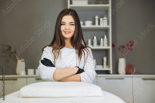 Consultation in cosmetology clinic. Female beauty doctor in white coat and black gloves crossed hands. Healthcare concept.