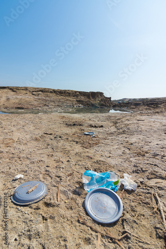 Plastic waste and disposable plates on the shore of the Dead Sea, Israel