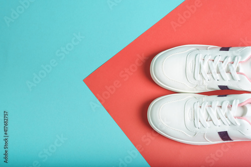 Flat lay of sport sneakers shoes on the blue and red colored background. Fitness background. Healthy lifestyle concept.