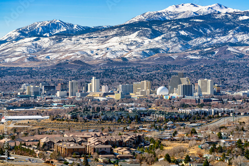 City of Reno Nevada cityscape showing the downtown skyline with Hotels, Casinos and the surrounding residential area with snow capped mountains background.
