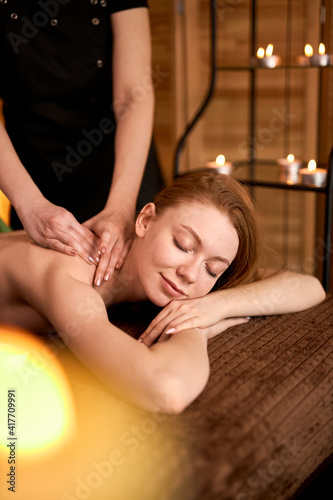 Massage, Spa, Health, Wellness Retreats concept. Cropped Professional Masseur doing massage on female back in spa salon.