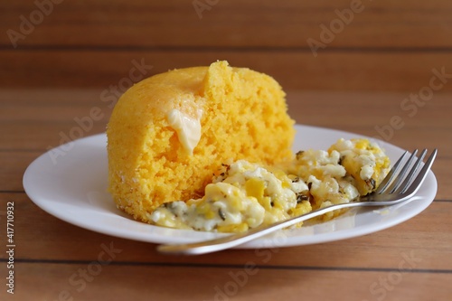 Brazilian couscous and scrambled eggs (Cuscuz com ovo) on wooden background. Typical Couscous of Northeast of Brazil.