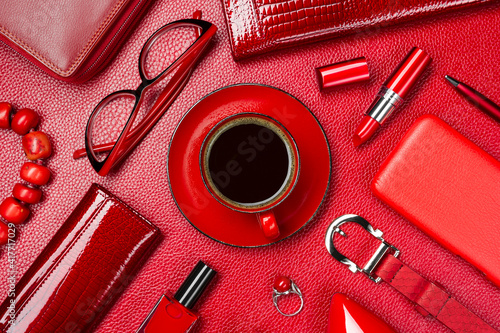 Woman red accessories with coffee, cosmetic, jewelry, gadget and other objects on leather background, fashion industry, modern female concept, selective focus 