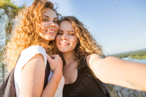 Two girls on a hike in the mountains take a selfie