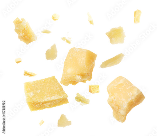 Pieces of delicious parmesan cheese flying on white background