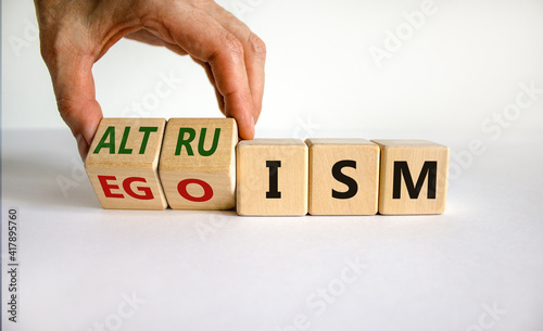 Altruism or egoism symbol. Businessman turns wooden cubes and changes the word 'egoism' to 'altruism'. Beautiful white background, copy space. Business, psychological and altruism or egoism concept.