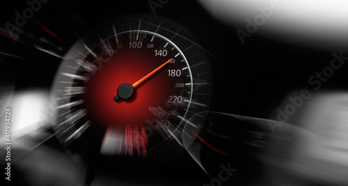 The speedometer of a modern car shows a high driving speed. Added motion blur.