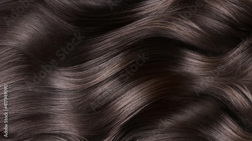 A closeup view of a bunch of shiny curls brown hair