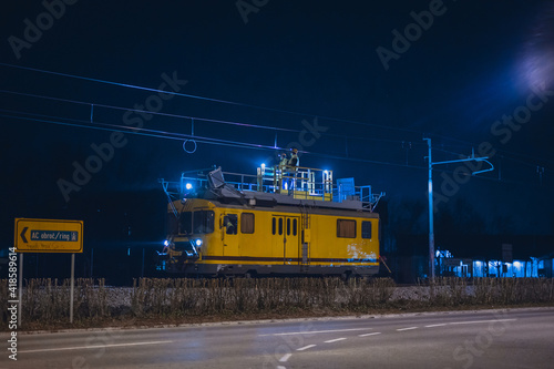 Work train for catenary maintenance at night. Workers working at night to allow the railway line to be opened in the morning.