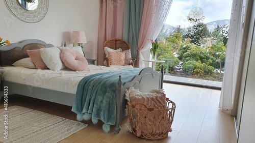 Elegancka stylizowana sypialnia w domu z dużym oknem i pieknym widokiem