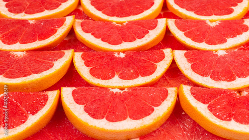 Grapefruit red juicy slices background. top view.