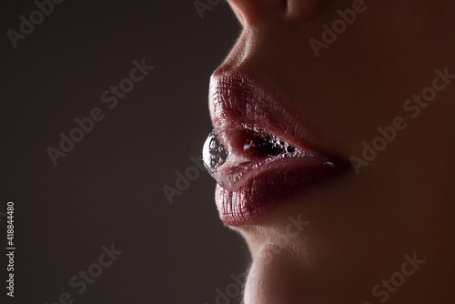 Closeup female open mouth with film of saliva. Saliva drips from erotic mouth.