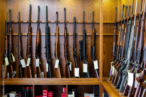 Gun shop interior with hunting and sporting rifles standing in row on display stand