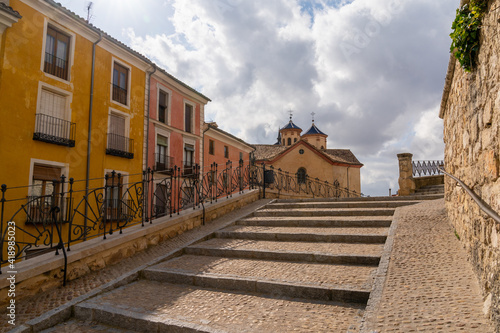 cobblestone stairs leading into the heart of the old city center of Cuenca witl El Salvador church in the background