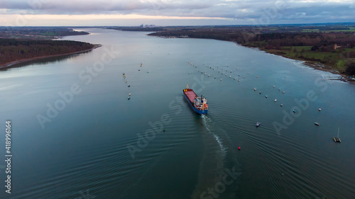 A cargo ship sailing down the River Orwell in Suffolk, UK