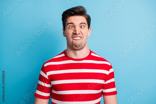 Photo portrait of silly comic man grimacing fooling in striped t-shirt isolated on bright blue color background
