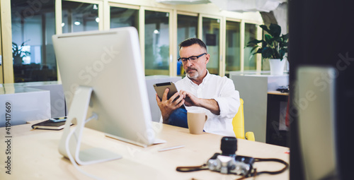 Photographer browsing tablet at coffee break in office