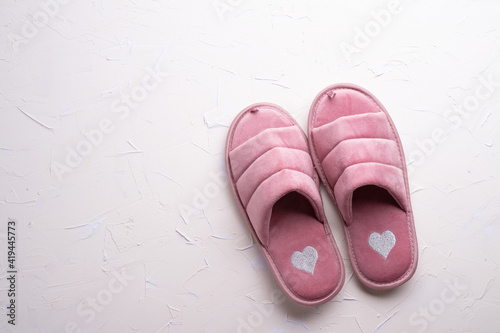 cozy home pink slippers against white background. concept composition