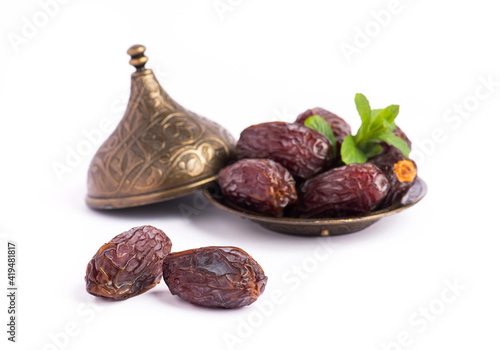 HURMA, Dates. Dried dates fruit with bronze bowls on white background. Popular fruit of Ramadan.