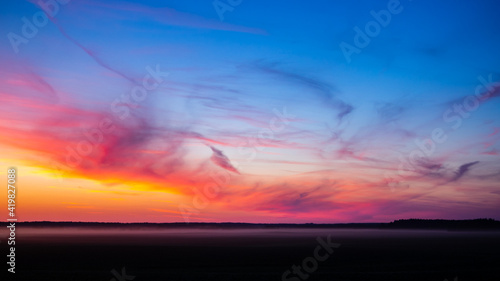 incredible colorful summer sunset over the field, unusual clouds of different shapes