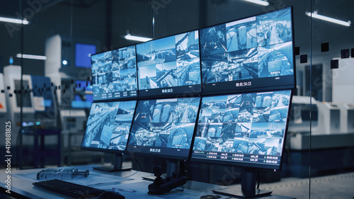 Industry 4.0 Modern Factory: Security Control Room with Multipoke Computer Screens Showing Surveillance Camera Feed. High-Tech Security