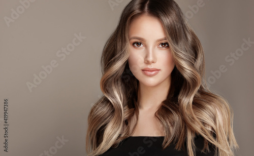 Beauty girl with long and shiny wavy Hair ,coloring and toning, shatush and balayash . Beautiful woman model with curly hairstyle .