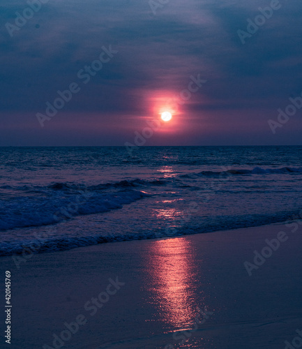 Niebiesko fioletowy mroczny zachód słońca, krajobraz wybrzeża z oceanem.