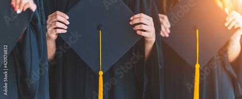 Close up group of graduates holding a hat At the graduation ceremony at the university