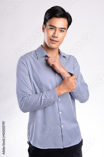 handsome confident young man standing and smiling in a blue shirt. on white background.