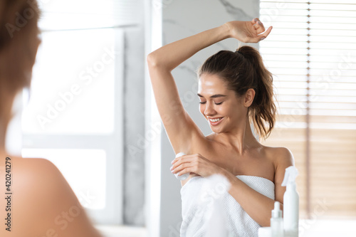 Woman Applying Antiperspirant On Armpits Preventing Sweating Standing In Bathroom