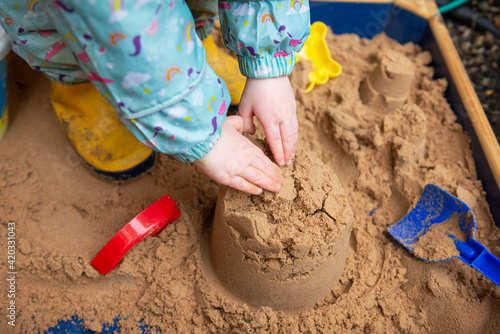 A child playing with sand in a sand pit