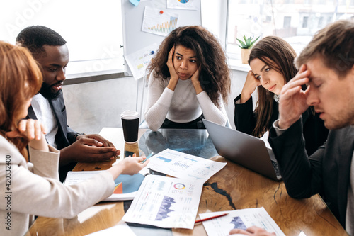 Tired business team are having a briefing meeting, can't find ideas for project. Exhausted male and female employees fail a startup, upset about work troubles, unsuccess and overwork concept