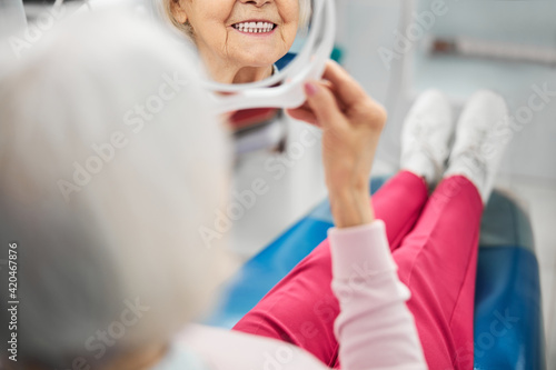 Teeth of aged lady in a little mirror
