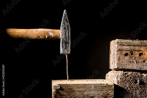 martello colpisce un chiodo dentro una tavola di legno