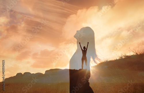 Happy woman on a mountain looking up to the sky. Letting go of all your mental fears. Hope, mental strength concept. Double exposure. 