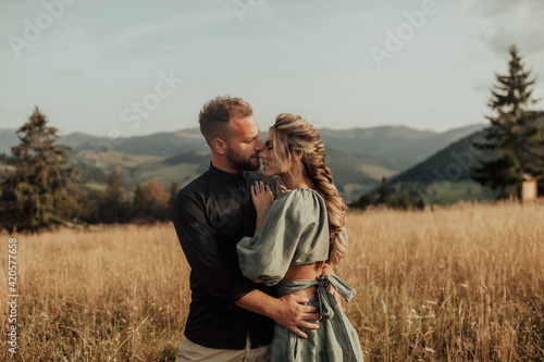 A beautiful and smiling young couple in love spend time in the mountains