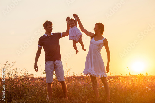 Mother, father and child daughter having fun outdoors.