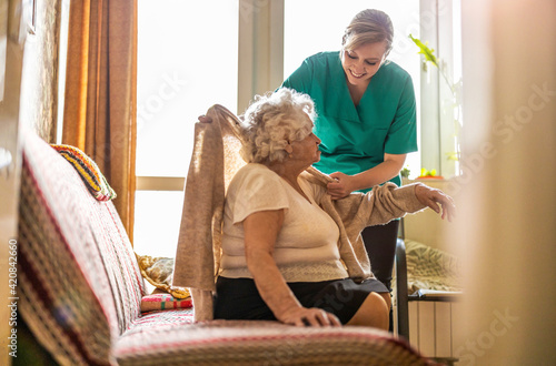 Female nurse taking care of a senior woman at home 