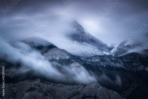 Clouds swirling around the mountains of Jasper National Park during a moody Summer morning.