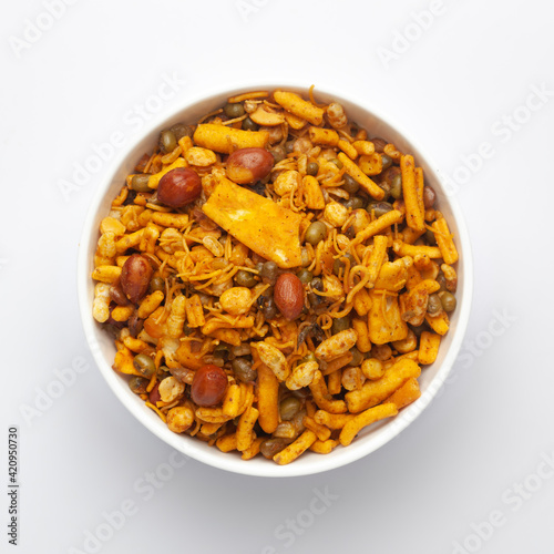 Close up of spicy Ratlami mixture Indian namkeen (snacks) on a ceramic white bowl. Top view