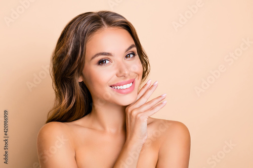 Photo of nice long hairdo optimistic lady without clothes hand face isolated on pastel beige color background