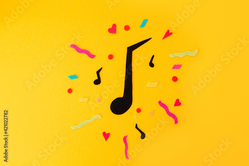 Festival and holiday. A cutted out of felt big note on a yellow background. Flat lay. International Jazz Day
