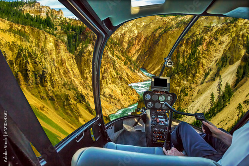 Helicopter cockpit pilot arm flight over Lower Falls, most popular waterfall in Yellowstone, located in head of Grand Canyon in Yellowstone River of Yellowstone National Park, Wyoming, United States.