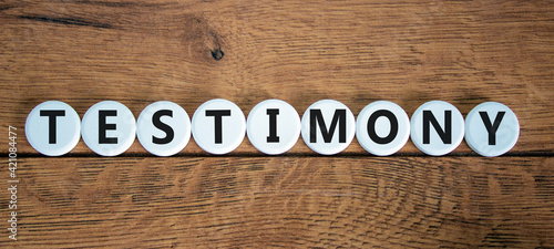 Testimony symbol. White circles with the word 'testimony'. Beautiful wooden background. Business, testimony concept. Copy space.